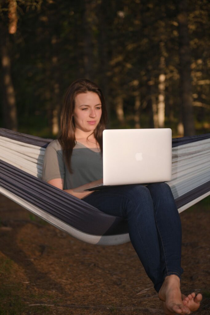Ana McRae working on laptop on hammock