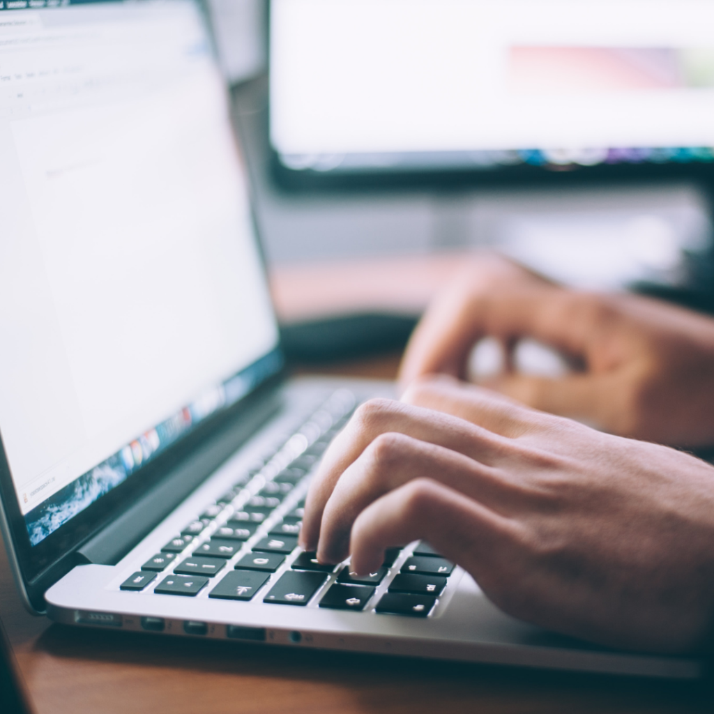 person typing on computer wondering how to find a life coach and what to look for in a life coach